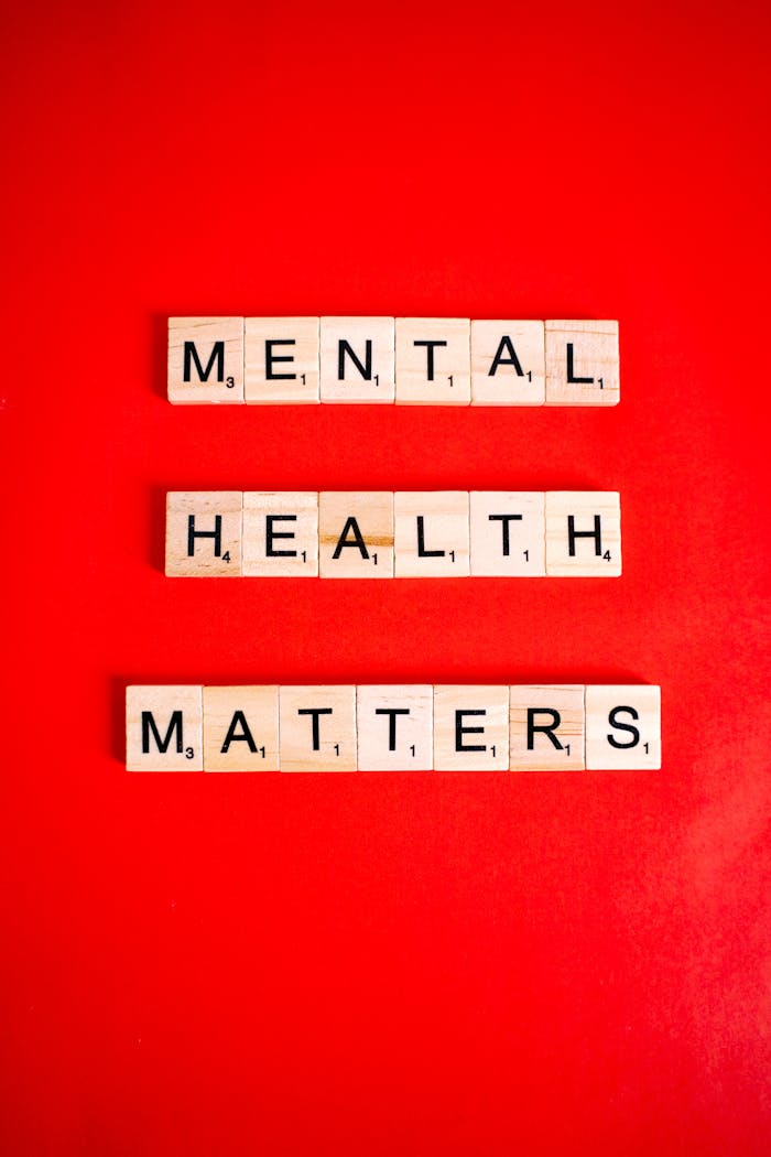 Wooden letter tiles spelling Mental Health Matters on a red background.